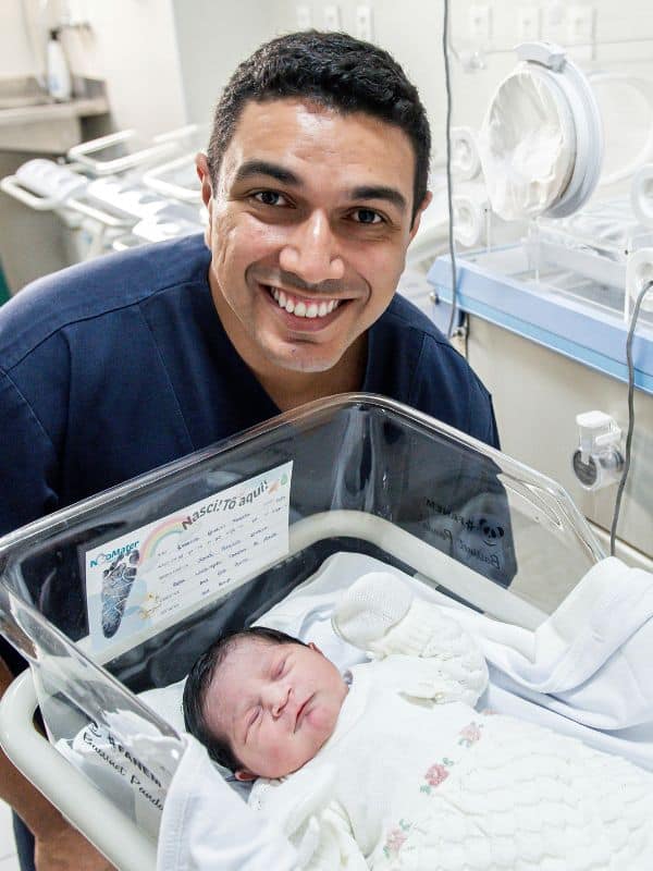 Man Smiling near to born baby