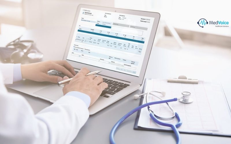 Healthcare professional reviewing billing and coding documents on a computer.