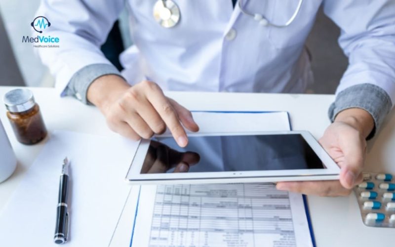 Doctor holding a clipboard while discussing credentials with admin staff